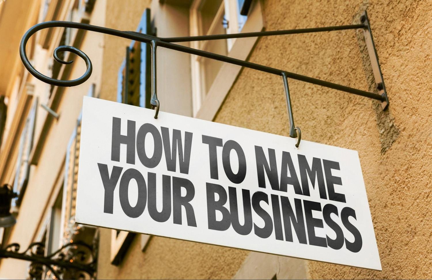 Signboard reading How To Name Your Business, illustrating brand and domain identity for UAE companies